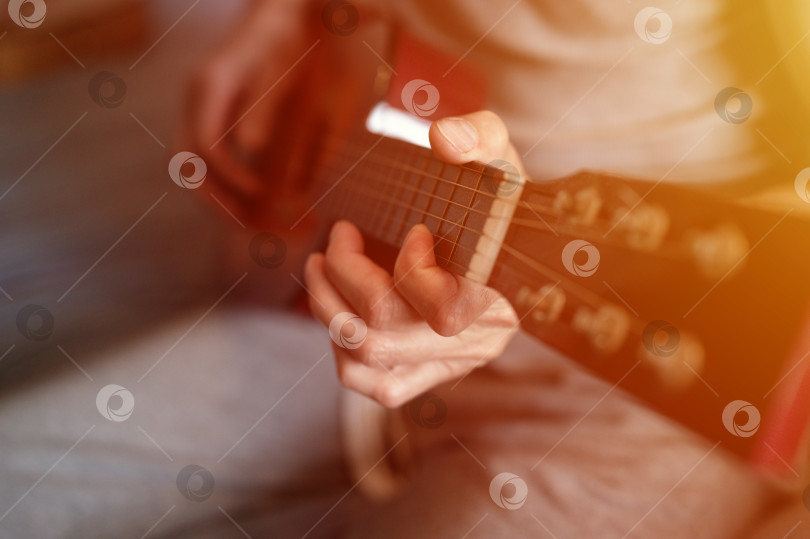 Скачать мужские руки пожилого пожилого кавказца, держащего классическую гитару и играющего на ней крупным планом дома. непрофессиональные безликие гитаристы играют любительскую музыку. домашние хобби и досуг фотосток Ozero
