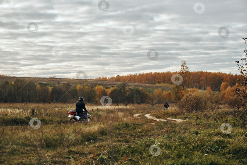 Скачать Осень, поездки на мотоцикле по пересеченной местности, мотоциклы. Осенний пейзаж, на горизонте поля и леса соседствуют с небом с облаками, по грунтовой дороге едет мотоциклист фотосток Ozero