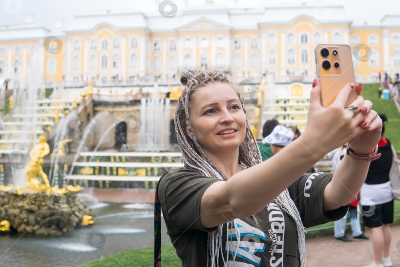 Скачать турист делает селфи перед Большим каскадом в дворцовом парке Петергоф, Санкт-Петербург фотосток Ozero