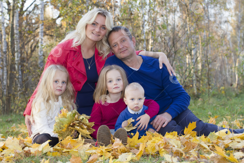 Скачать Семейный портрет осенью. Мама, папа, дочери и сын на прогулке фотосток Ozero
