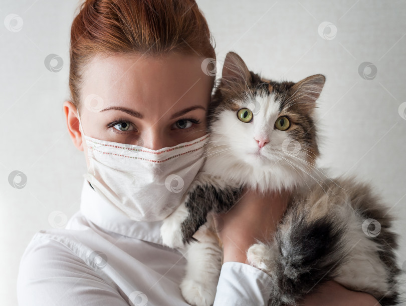 Скачать Портрет девушки в медицинской маске. Она держит на руках любимую кошку. Закрыть фотосток Ozero