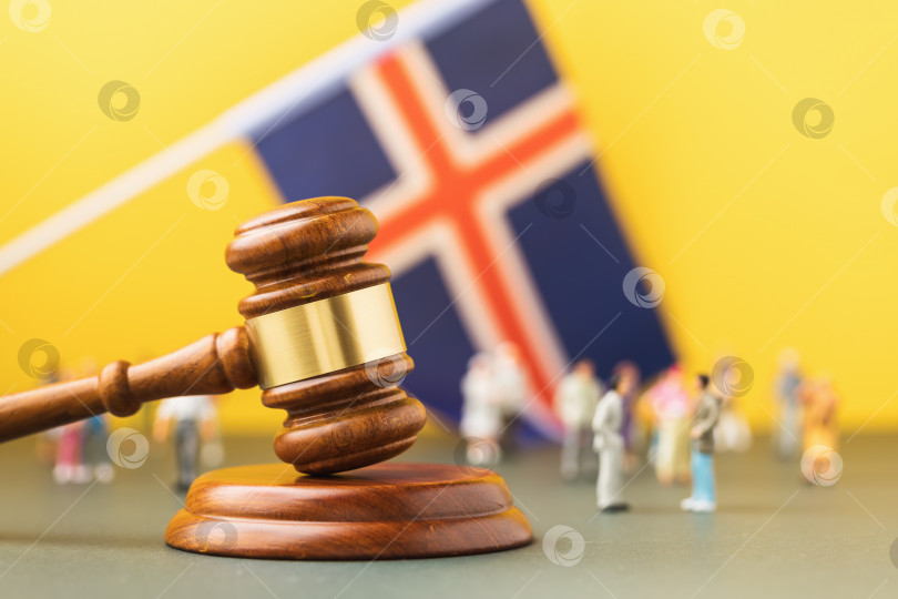 Скачать Судейский молоток, исландский флаг и пластмассовые игрушечные человечки на цветном фоне - концепция судебного разбирательства в исландском обществе фотосток Ozero