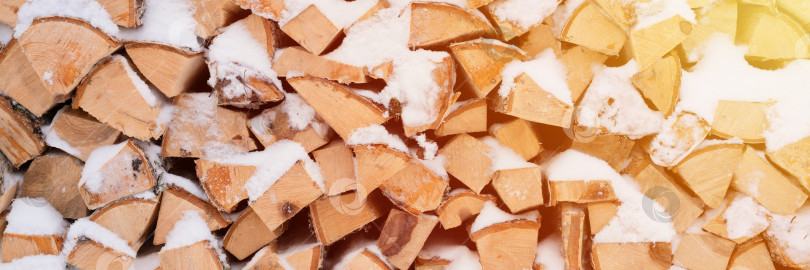 Скачать текстурированный фон для дров колотая древесина для растопки. поленница с сложенными дровами березового дерева покрыта свежим обледенелым снегом и снежинками. холодная погода и снежное зимнее время года фотосток Ozero