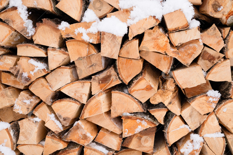 Скачать текстурированный фон для дров колотая древесина для растопки. поленница с сложенными дровами березового дерева покрыта свежим обледеневшим снегом и снежинками. холодная погода и снежное зимнее время года фотосток Ozero