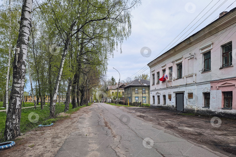 Скачать Старая ухабистая асфальтированная дорога через город, запустение, пустые улицы фотосток Ozero