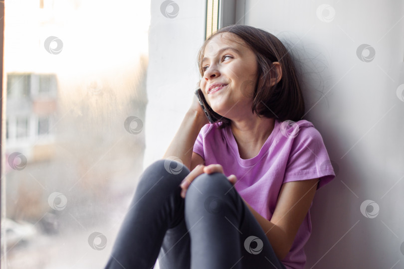 Скачать Девочка-подросток, сидящая на подоконнике фотосток Ozero