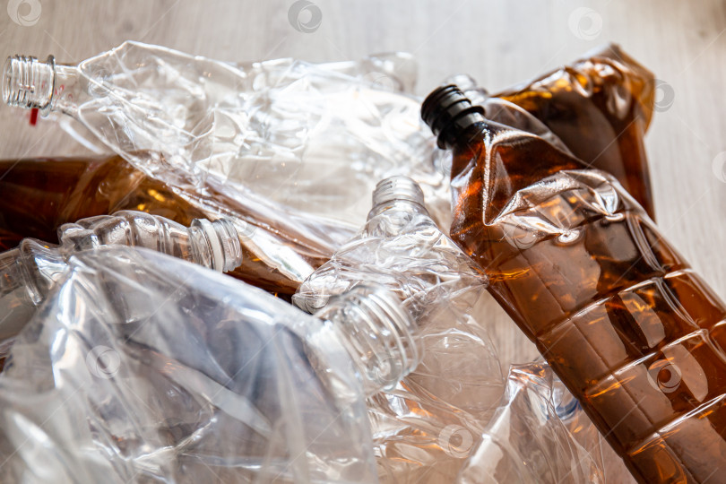 Скачать Смятые пластиковые бутылки на полу дома, приготовленные для вторичной переработки. фотосток Ozero