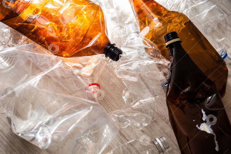 Скачать Смятые пластиковые бутылки на полу дома, приготовленные для вторичной переработки. фотосток Ozero
