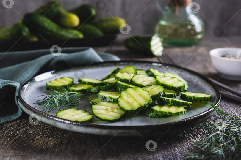 Скачать Подаем на стол с нарезанными свежими огурцами и зеленью укропа на тарелке фотосток Ozero