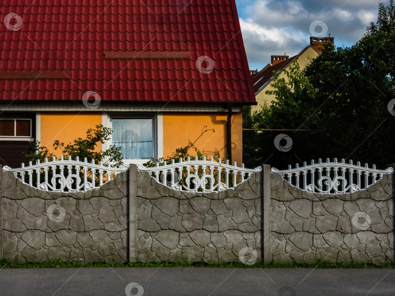 Скачать каменный и белый кованый забор возле дома фотосток Ozero