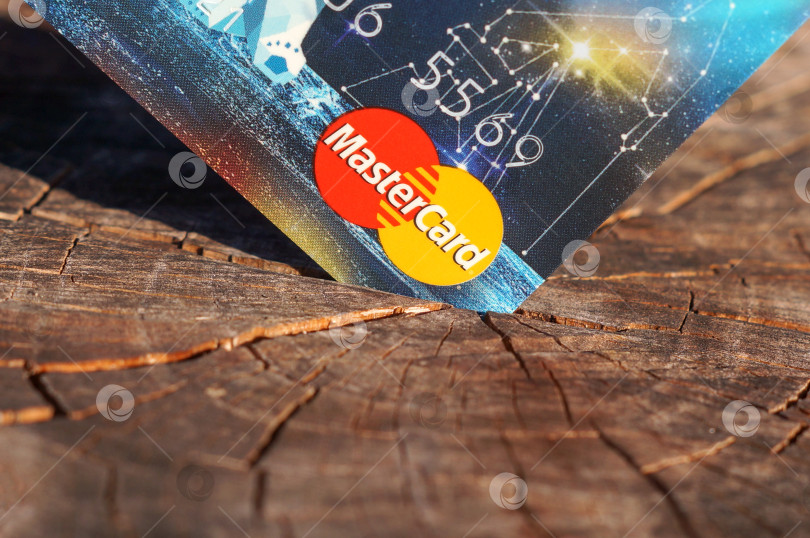 Скачать Саратов, Россия - 25 июня 2024 года. Банковская карта MasterCard в пеньке фотосток Ozero