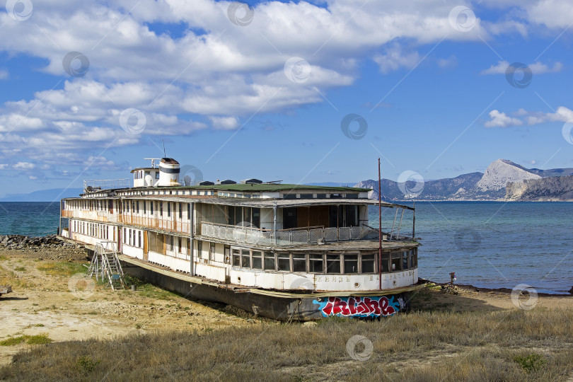 Скачать На берегу моря стоит старая заброшенная речная лодка. фотосток Ozero