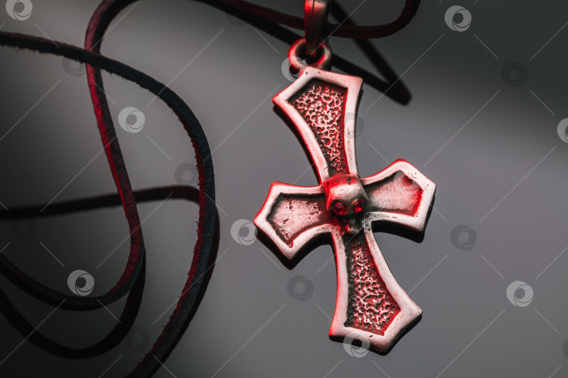 Скачать Крест с кожаным шнурком на градиентном фоне, крупным планом фотосток Ozero