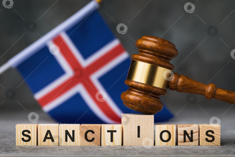 Скачать Судейский молоток, деревянные кубики с текстом на фоне исландского флага, концепция на тему санкций в Исландии фотосток Ozero