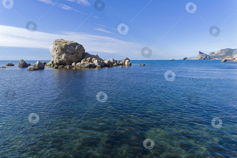 Скачать Небольшой скалистый островок недалеко от берега моря. фотосток Ozero