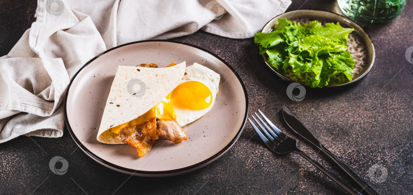 Скачать Кесадилья с жареным яйцом, беконом и сыром на тарелке на столовом веб-баннере фотосток Ozero