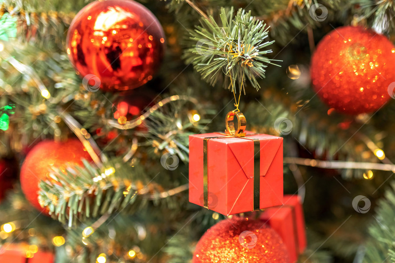 Скачать Рождественская елка, украшенная красным шаром и подарочными коробками. Фон с боке. новый год фотосток Ozero
