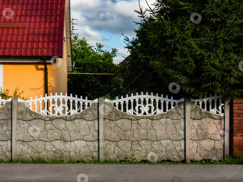 Скачать каменный и белый кованый забор возле дома фотосток Ozero