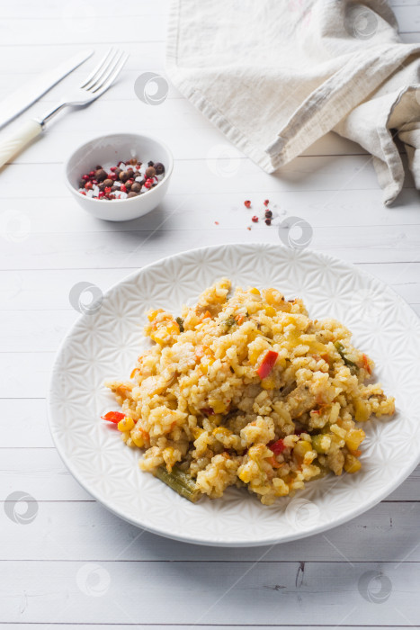 Скачать Плов с овощами и курицей в серой тарелке на светлом фоне. фотосток Ozero