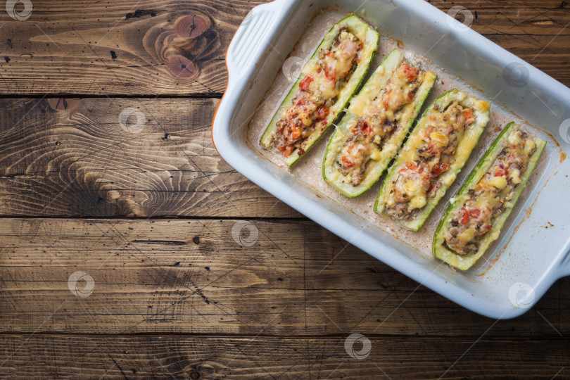 Скачать Запеченные лодочки из кабачков с начинкой из куриного фарша, грибов и овощей с сыром на противне. Вид сверху фотосток Ozero