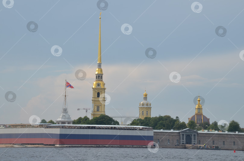 Скачать Санкт-Петербург, Россия – 07.27.2024: Петропавловская крепость на Заячьем острову в Санкт-Петербурге, крепостные стены украшены растяжкой в цветах флага Российской Федерации фотосток Ozero