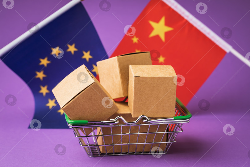 Скачать Картонные коробки в корзине с продуктами, флаги Китая и Европейского Союза на цветном фоне, концепция торговли между странами фотосток Ozero