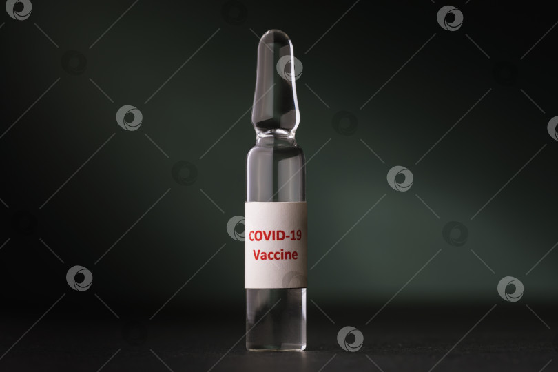 Скачать Ампула с вакциной против коронавируса на темном фоне фотосток Ozero