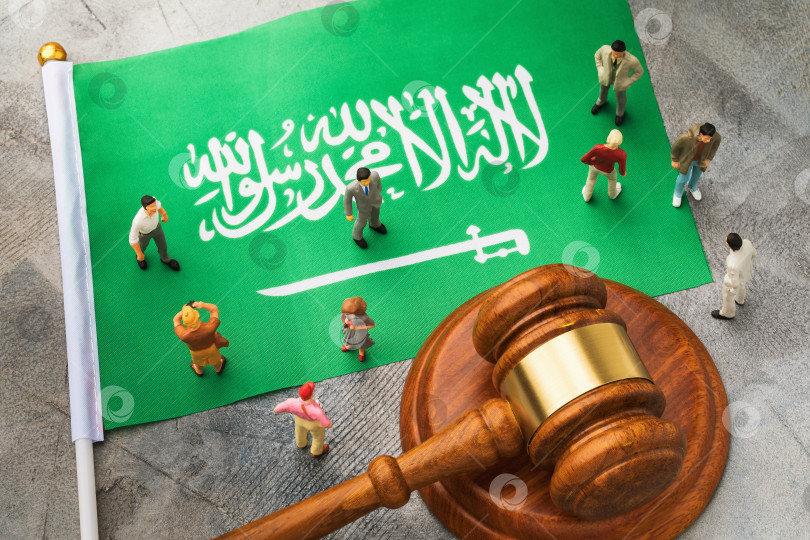 Скачать Судейский молоток, флаг Саудовской Аравии и пластмассовые игрушечные человечки на абстрактном фоне, концепция судебного разбирательства в обществе фотосток Ozero