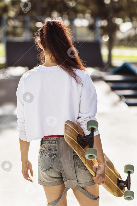 Скачать Девушка катается на лонгборде в скейт-парке фотосток Ozero