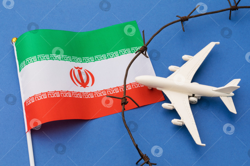 Скачать Игрушечный самолет, иранский флаг и колючая проволока на цветном фоне, концепция нарушения воздушной границы Ирана фотосток Ozero
