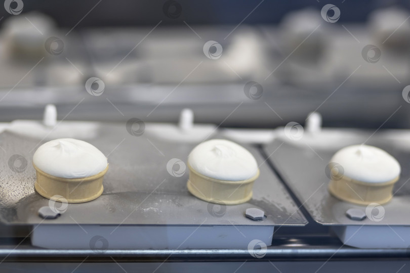 Скачать Автоматическая линия по производству мороженого - конвейерная лента с рожками для мороженого на современном заводе по переработке пищевых продуктов. Концепция оборудования для пищевой и молочной промышленности, производства, инжиниринга и автоматизированных технологий фотосток Ozero