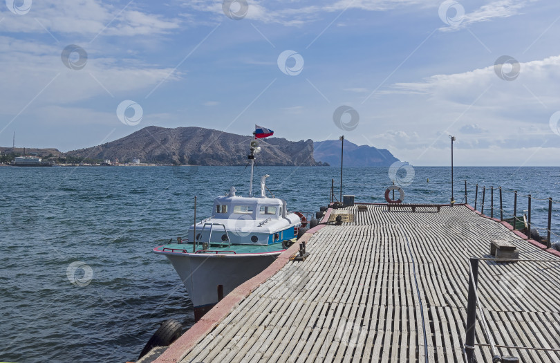 Скачать У пирса пришвартована небольшая лодка. фотосток Ozero