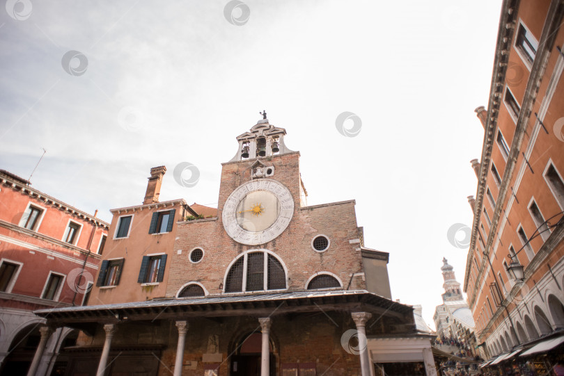 Скачать Церковь Сан-Джакомо ди Риальто со старинными зданиями, построенными из красного кирпича. фотосток Ozero