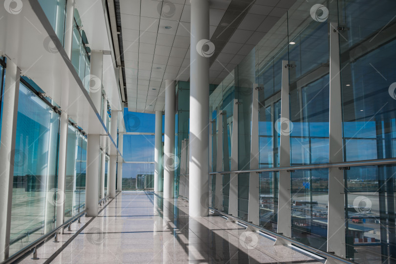 Скачать Пустой зал аэропорта со стеклянными окнами и белой колонной. фотосток Ozero