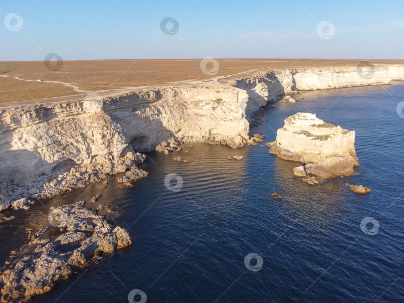 Скачать Мыс Тарханкут с бирюзовой водой на западном побережье полуострова Крым. Летний морской пейзаж, известное место для путешествий. Живописный морской пейзаж, пляж на побережье Крыма, Черное море, горы Ялты. Скалистый обрыв, уходящий в море фотосток Ozero