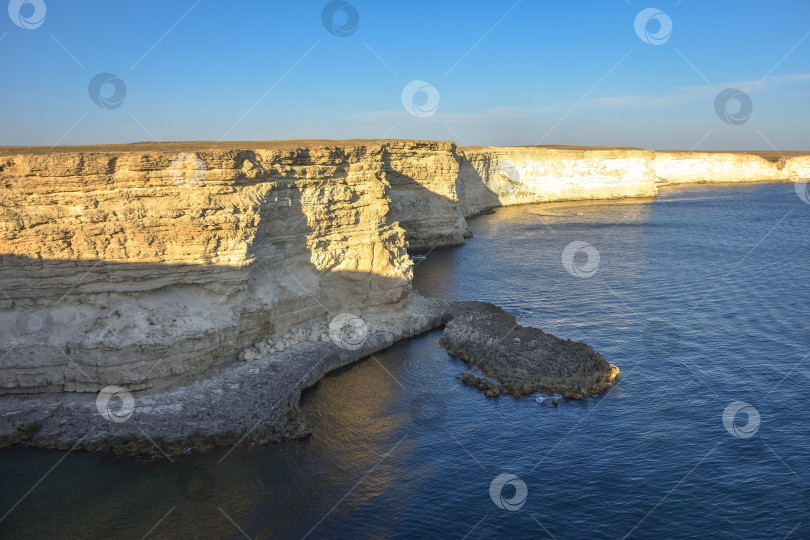 Скачать Мыс Тарханкут с бирюзовой водой на западном побережье полуострова Крым. Летний морской пейзаж, известное место для путешествий. Живописный морской пейзаж, пляж на побережье Крыма, Черное море, горы Ялты. Скалистый обрыв, уходящий в море фотосток Ozero