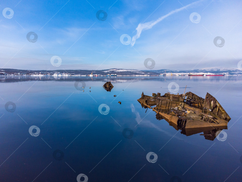 Скачать вид на доки зимой с моря. ржавый остов на переднем плане. фотосток Ozero