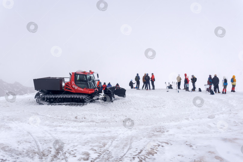 Скачать перевозка туристов через тающий ледник на снегоходе в облаке на склонах горы Эльбрус фотосток Ozero