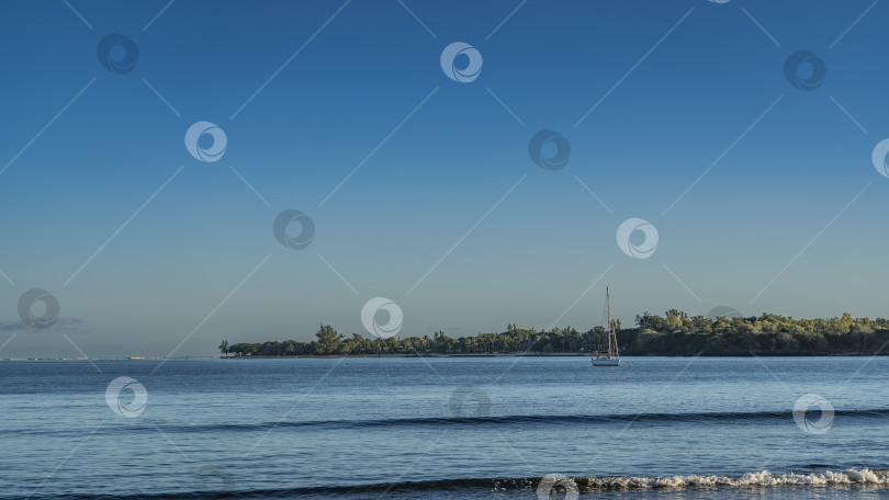 Скачать Спокойный голубой океан. Волны медленно накатываются на берег. фотосток Ozero