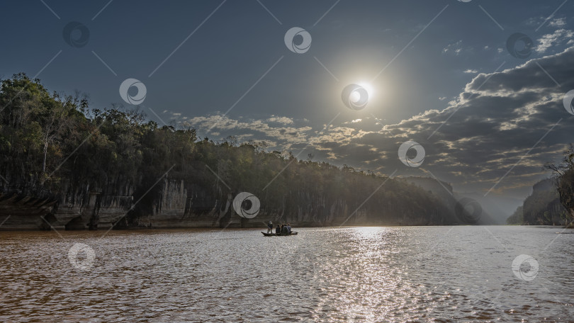 Скачать Каноэ с туристами плывет по красно-коричневой реке. фотосток Ozero