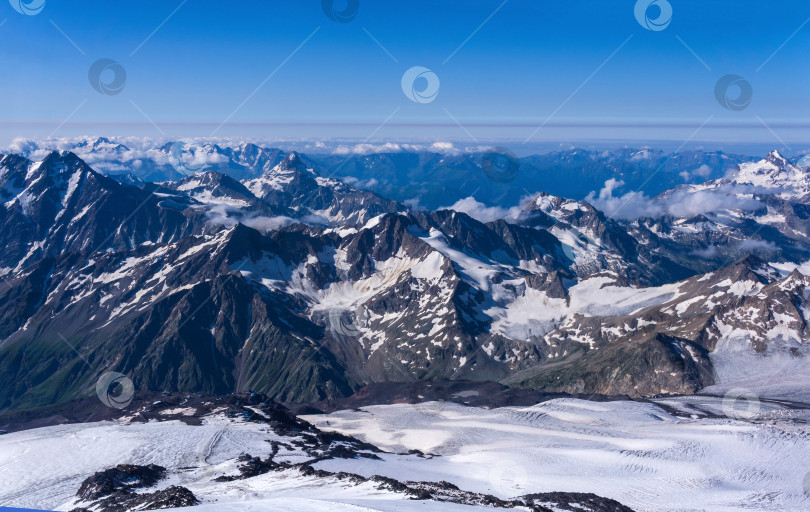 Скачать вид сверху на высокие горы над облаками со склона горы Эльбрус фотосток Ozero