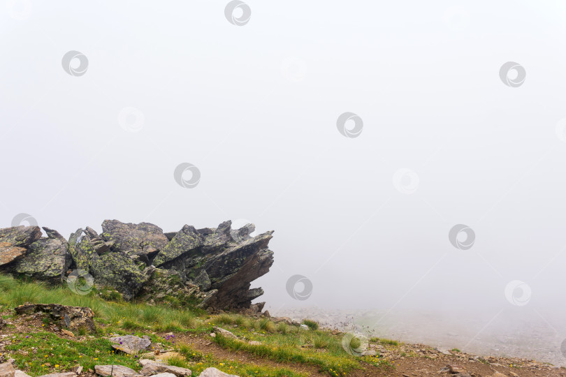 Скачать горный пейзаж, скалы на склоне горы в густом тумане фотосток Ozero