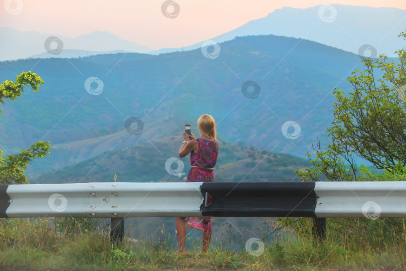 Скачать Европейская девушка фотографирует горный пейзаж фотосток Ozero