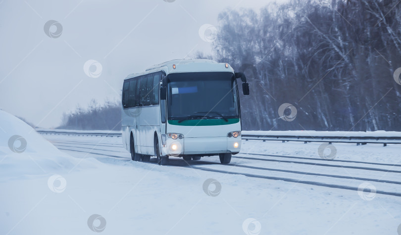 Скачать Автобус движется по зимней заснеженной дороге фотосток Ozero