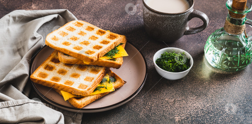 Скачать Вкусный сэндвич из вафельных тостов с плавленым сыром и зеленью на тарелке-баннер фотосток Ozero