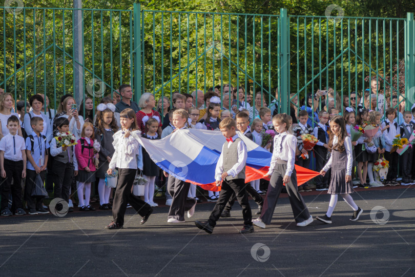 Скачать Дети школьники несут флаг России. фотосток Ozero