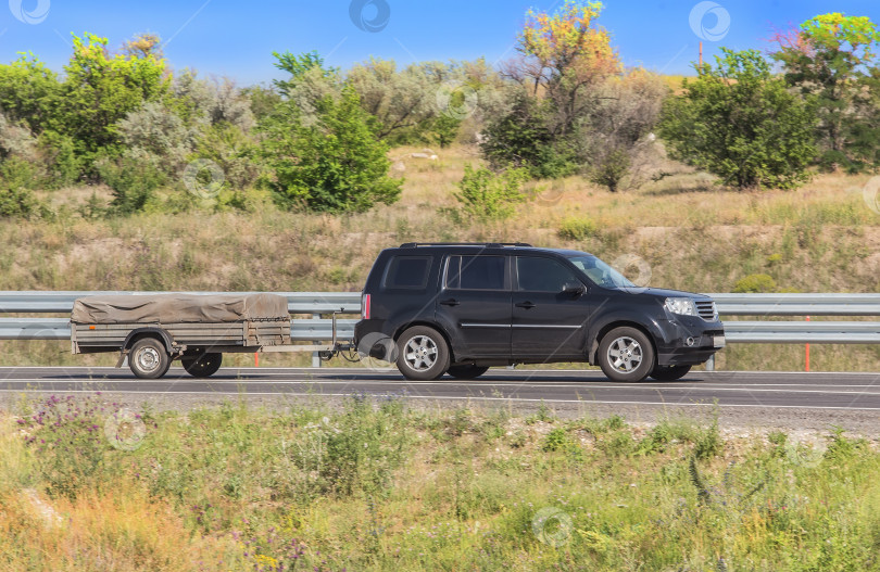 Скачать Автомобиль с прицепом движется по проселочной дороге фотосток Ozero