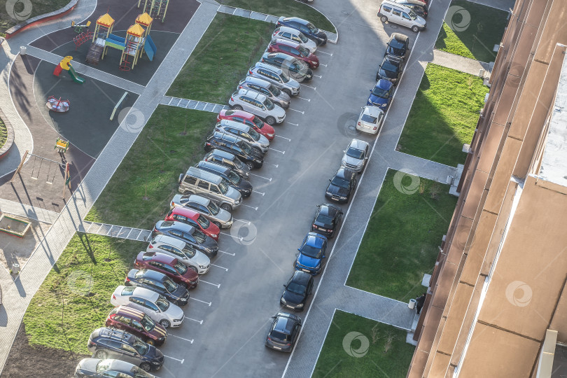 Скачать Автомобили припаркованы во дворе жилого многоквартирного дома. фотосток Ozero