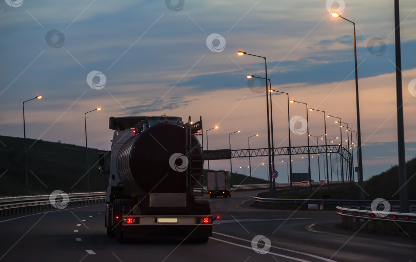 Скачать Грузовик с автоцистерной движется по ночному шоссе фотосток Ozero