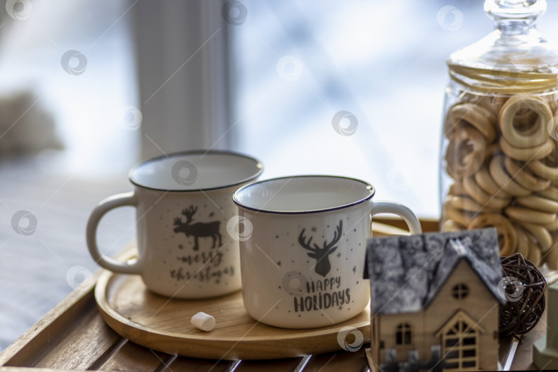 Скачать Утренний рождественский кофе с зефиром и рождественскими украшениями на подносе столик у окна на подоконнике фотосток Ozero